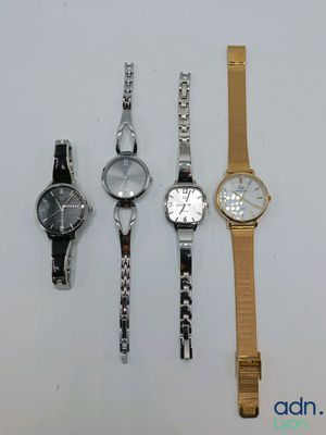 four different watches are lined up on a white surface