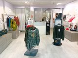 une photo d'un magasin de vêtements avec des vêtements en vitrine