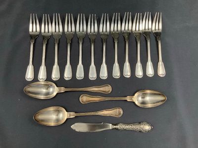 un grand nombre de cuillères et de fourchettes en argent disposées sur une table
