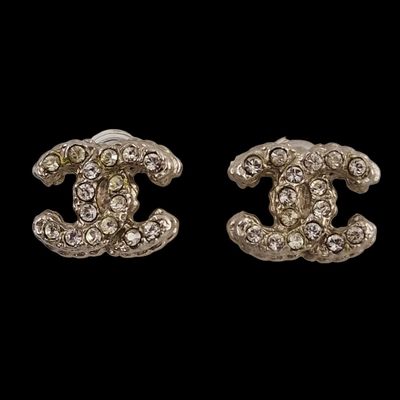 a pair of chanel earrings with diamonds on a black background