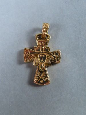 gros plan d'une croix en or sur une surface blanche