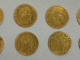 a group of six gold coins sitting on top of a white surface