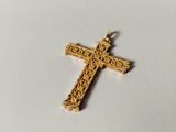 a close up of a gold cross on a white surface