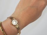a woman ' s hand with a watch on it ' s wrist