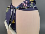 a close up of a mannequin torso with a flowered scarf tied to it
