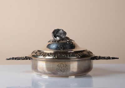 a silver bowl with a dog on it sitting on a table
