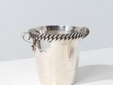silver plated ice bucket with rope handles on a white surface