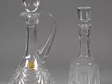 two glass decanters sitting next to each other on a table