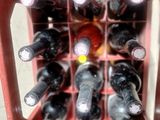 bottles of wine are in a red wine rack on a table