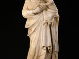 une statue en marbre blanc représentant une femme tenant un enfant dans ses bras