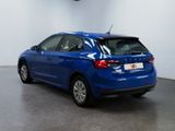 the rear end of a blue car in a white room