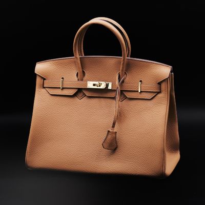 a brown leather handbag on a black background