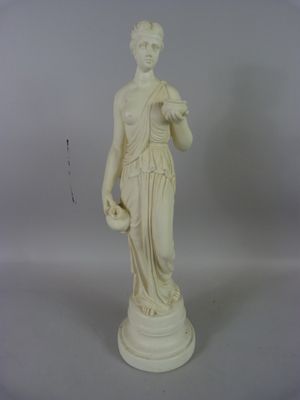 une statue blanche représentant une femme tenant une fleur