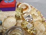 many different types of rings and bracelets on a tray