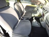 the interior of a small car with two seats and a steering wheel