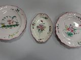 three plates with floral designs are sitting on a white surface