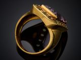 a close up of a gold ring with a purple stone in it