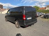 une camionnette noire garée sur un parking à côté d'un immeuble