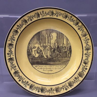 une vieille assiette sur laquelle est représenté un homme et une femme