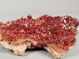 a close up of a piece of rock with a lot of red crystals on it
