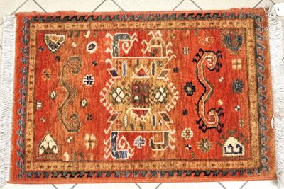 un tapis orange à motifs posé sur un sol blanc