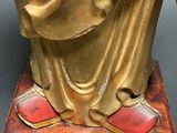 a gold statue of a man holding a book