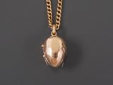 a gold heart locke necklace with a chain on a black background
