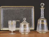 trois objets en verre posés sur une table à côté d'un cadre photo