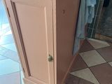 a small cabinet with a towel rack in the corner of the room