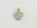 un gros plan d'un pendentif en forme de cœur en diamant posé sur une surface blanche