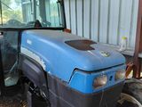 un tracteur bleu garé devant un bâtiment