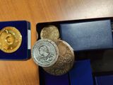 a gold coin and a silver coin in a blue box