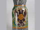 a vase with a coat of arms and a crown on it