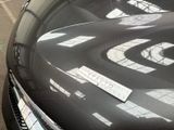 a black car with a sticker on it parked in a parking lot