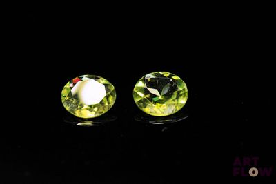 pair of green crystal stud earrings on black background