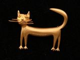 une broche en forme de chat doré sur fond noir