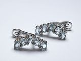 paire de boucles d'oreilles en argent ornées de cristaux bleus sur fond blanc