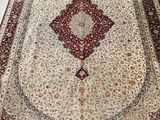 a close up of a red and white rug on a white floor