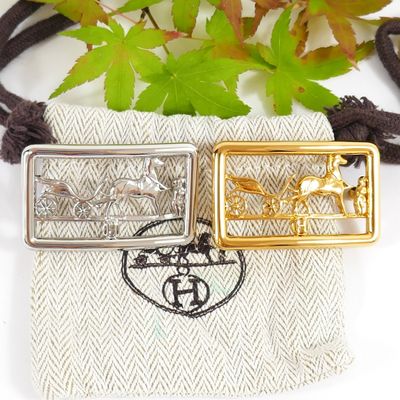 two gold and silver pendants sitting on top of a cloth bag