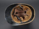 an old helmet with a leather band and a metal buckle