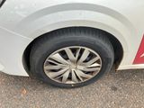 a white car with a red stripe parked on the side of the road