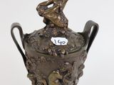 a bronze vase with a boy on top of it