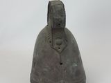 a metal bell that is sitting on a white surface