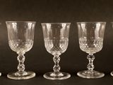 quatre verres à vin vides alignés sur une surface noire