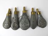 five antique brass and glass perfume bottles lined up on a white surface