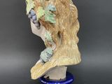 a close up of a statue of a woman with grapes on her head