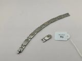 un gros plan d'un bracelet en métal auquel est attachée une étiquette