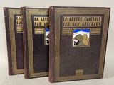 trois livres sont alignés sur une surface blanche