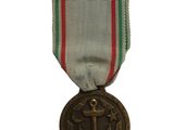 une vieille médaille entourée d'un ruban rouge, blanc et vert