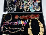 a black box filled with assorted jewelry on a white surface